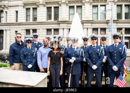 Cast members Brandon Victor Dixon (Aaron Burr) and Lexi Lawson (Eliza Hamilton) of the esteemed Broadway musical, Hamilton pose for a photo with the U.S. Coast Guard Silent Drill Team on the grounds of Trinity Church, in New York City, May 26, 2017. As a part of Fleet Week New York, crew members from the Coast Guard Cutter Hamilton and guests honored Coast Guard founder, Alexander Hamilton, with a memorial wreath-laying ceremony at his grave. U.S. Coast Guard photo by Petty Officer 1st Class LaNola Stone. Stock Photo