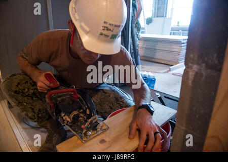 170535-N-XY744-015 NEW YORK (May 25, 2017) -- Construction Electrician 2nd Class Ben Coulson saws blocking at a Habitat for Humanity job site during Fleet Week New York (FWNY), May 25. FWNY, now in its 29th year, is the city's time-honored celebration of the sea services. It is an unparalleled opportunity for the citizens of New York and the surrounding tri-state area to meet Sailors, Marines and Coast Guardsmen, as well as witness firsthand the latest capabilities of today's maritime services. (U.S. Navy photo by Mass Communication Specialist 2nd Class Tyler Hogman/Released) Stock Photo