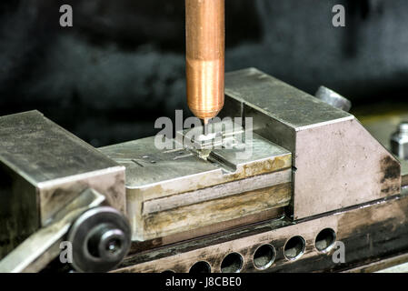 Automatic drilling machine in close-up working on producing metal mold Stock Photo