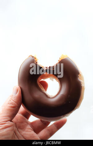 Chocolate coated doughnut with bite taken out isolated against white background Stock Photo
