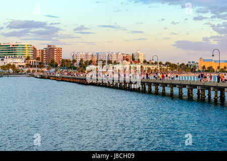 Melbourne, Australia - December 28, 2016: People walking along St. Kilda Beach jetty at sunset on a hot summer day Stock Photo