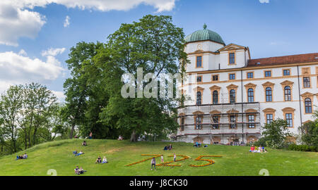 People sitting in the grass in front of the castle of Celle, Germany Stock Photo
