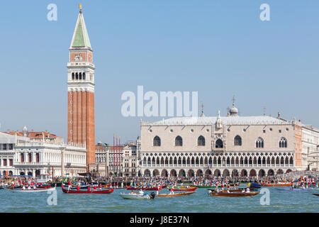 May 28th 2017 Venice, Veneto, Italy. Participants in the cortege for the Fete de la Sensa Venice, Veneto Italy with rowing teams in their boats in front of the Doges Palace and Campanile accompanying the Serrenisimo historial boat carrying the dignatories to Lido for the blessing of the gold ring which is then tossed into the lagoon marrying Venice to the sea. Stock Photo