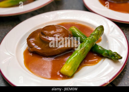 Cantonese cuisine whole abalone with asparagus Stock Photo