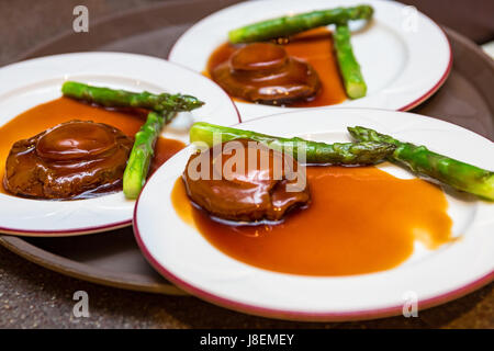 Cantonese cuisine whole abalone with asparagus Stock Photo