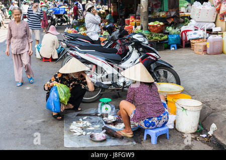 NHA TRANG, VIETNAM - JANUARY 20: Vietnamese woman in traditional conical hat is selling fish at the wet market on January 20, 2016 in Nha Trang, Vietn Stock Photo