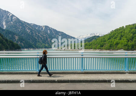 Female traveler and kurobe dam at tateyama kurobe alpine route in japan Stock Photo