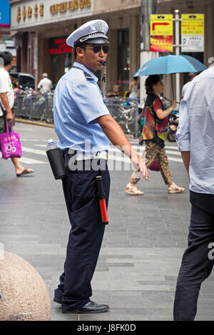 Police officer on Nanjing Road pedestrian street, Shanghai, China Stock Photo