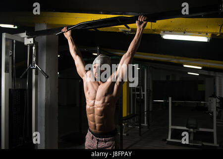 Male Athlete Doing Pull Ups - Chin-Ups In The Gym Stock Photo