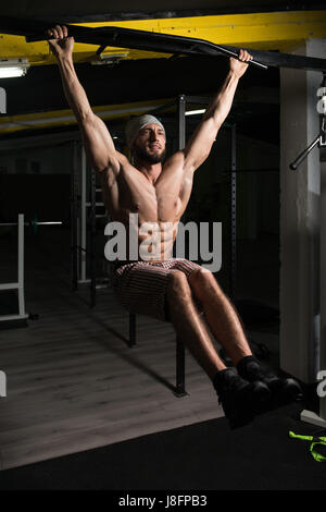 Male Athlete Doing Pull Ups - Chin-Ups In The Gym Stock Photo