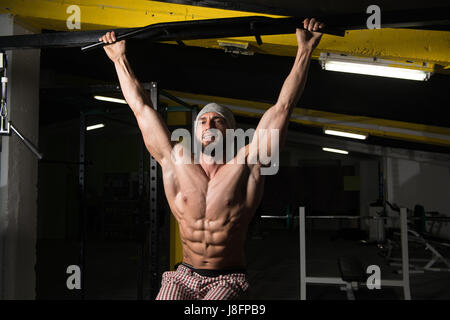 Male Athlete Doing Pull Ups - Chin-Ups In The Gym Stock Photo