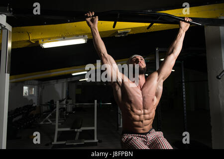 Male Athlete Doing Pull Ups - Chin-Ups In The Gym Stock Photo