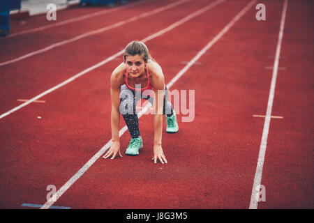 Muscular and beautiful girl doing exercises. Athletics girl, stadium Stock Photo