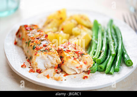 Tomato & basil chargrilled cod with green beans and potatoes Stock Photo
