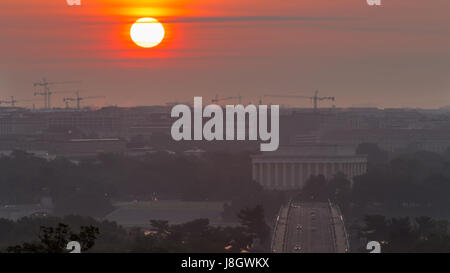 The sun rises over the memorials and construction cranes in Washington, D.C. Stock Photo