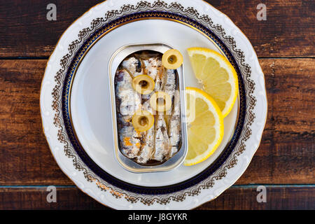 Can of canned oil sardines on a elegant plate. Healthy meal Stock Photo