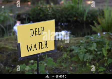 Deep water warning sign beside waters edge. Stock Photo