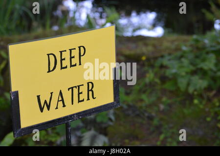 Deep water warning sign beside waters edge. Stock Photo