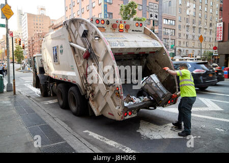 New York City depart of sanitation working emptying street waste bin into refuse garbage truck USA Stock Photo