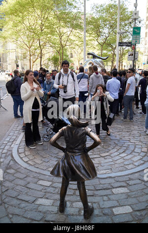 Fearless girl sculpture facing charging bull New York City public art bowling green broadway USA Stock Photo