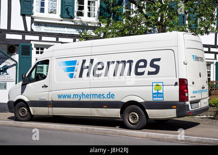 Hermes delivery van in front of a half-timber house. Hermes is Germany’s largest post-independent provider of deliveries to private customers. Stock Photo