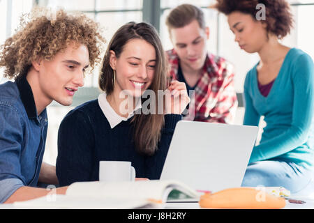 Two young students searching for an answer to their question bot Stock Photo