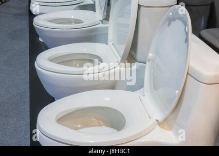 Picture of a bathroom flush in a showroom,Modern Toilet bowl in a men bathroom,white ceramic flush toilet Stock Photo