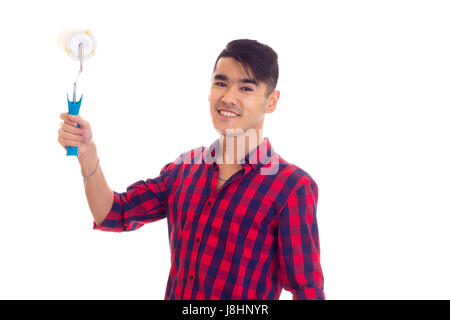 Young optimistic man with dark hair in red plaid shirt holding white roll on white background in studio Stock Photo