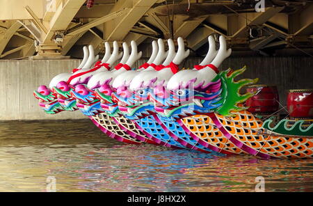 KAOHSIUNG, TAIWAN -- MAY 21, 2017: Traditional dragon boats are anchored under a bridge on the Love River in preparation for the upcoming Dragon Boat  Stock Photo