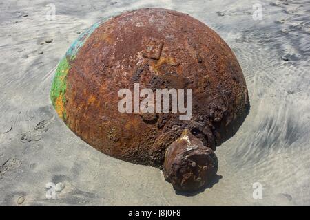 Old Rusted Sea Buoy Washed out by Pacific Ocean High Tide on Torrey Pines State Black Beach Sand north of La Jolla Shores in San Diego California US Stock Photo