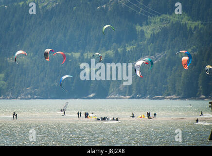Kite boarders stand on an sand bar near Squamish Terminals.  An extra low tide exposed the normally submerged sand bar.  Saturday, May 27, 2017.  Phot Stock Photo