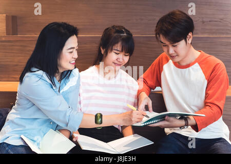 close up at Groups of asian teenage students studying together at university stair library. Stock Photo