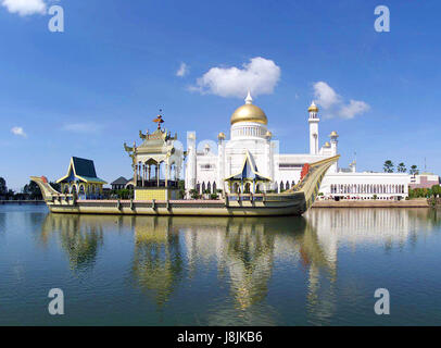A bit of classical Islamic architecture in downtown Bandar, Brunei, the Omar Ali Saifuddien Mosque stands as a tribute to Sultan Sir Muda Omar Ali Saifuddien. The Sultan, father of His Majesty Sultan Hassanal Bolkiah, is regarded as the architect of modern Brunei.  Anchored in a lagoon beside the Mosque is a replica of a 16th century Mahligai, or royal barge, where religious ceremonies were held during the 1960’s and 1970’s. Stock Photo