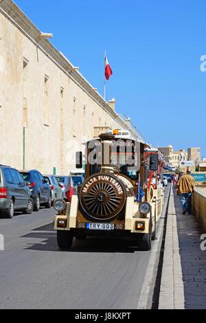 Tourist land train passing the Holy Infirmary along Triq Il-Mediterran, Valletta, Malta, Europe. Stock Photo