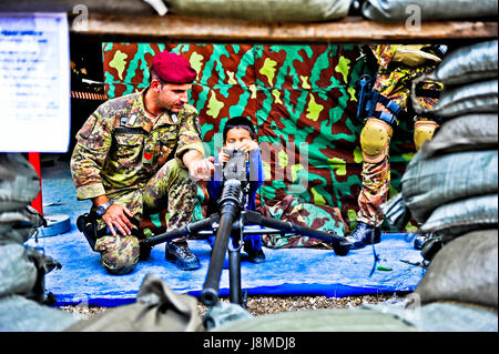 A young children playing with a heavy machine gun Stock Photo