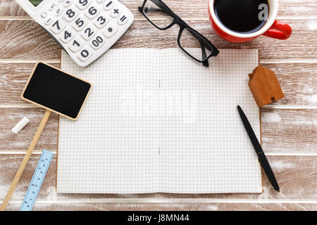 Blank notebook with house for sale sign and calculator for property taxes and mortgage concept Stock Photo