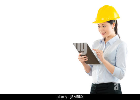 mixed race asian chinese model construction worker using digital tablet with copyspace on the white wall background holding the pad check design image Stock Photo