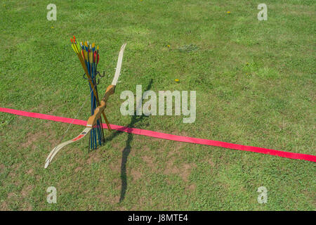 Sports target bow and arrows at the standing line on an archery range. Stock Photo