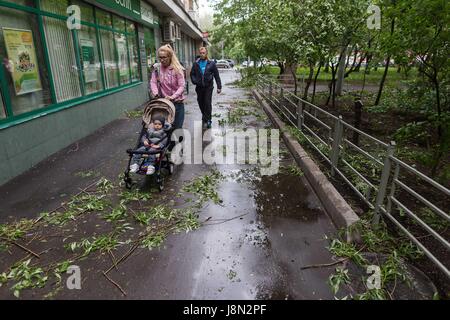 Moscow, Russia. 29th May, 2017. People walk past fallen branches of trees after a storm in Moscow, Russia, on May 29, 2017. A sudden storm killed at least 11 people in Moscow Monday afternoon and forced 50 others to seek medical assistance, local media reported. Credit: Evgeny Sinitsyn/Xinhua/Alamy Live News Stock Photo