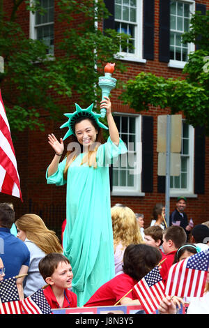 Westminster, Maryland, USA. 29th May, 2017. An Asian American girl dressed as the Statue of Liberty waves to spectators while taking part in parades for Memorial Day, a federal holiday in the United States for remembering those who died while serving in the country's armed forces. Credit: James Brunker/Alamy Live News Stock Photo