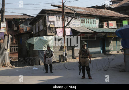 Srinagar, Kashmir. 30th May, 2017. Indian paramilitary troopers stand guard near a barricade at a street during curfew-like restrictions in downtown Srinagar, summer capital of Kashmir, May 30, 2017. Curfew-like restrictions have been imposed in several areas of Srinagar to prevent protests and clashes. Credit: Javed Dar/Xinhua/Alamy Live News Stock Photo
