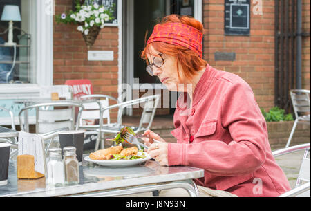 A lady eating lunch outside at a cafe in the UK. Stock Photo