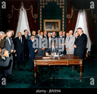 United States President John F. Kennedy signs the Limited Nuclear Test Ban Treaty in the White House Treaty Room on October 7, 1963. From left to right: William Hopkins, U.S. Senator Mike Mansfield (Democrat of Montana), John J. McCloy, Adrian S. Fisher, U.S. Senator John Pastore (Democrat of Rhode Island), W. Averell Harriman, U.S. Senator George Smathers (Democrat of Florida), U.S. Senator J.W. Fulbright (Democrat of Arkansas), U.S. Secretary of State Dean Rusk,  U.S. Senator George Aiken (Republican of Vermont), President Kennedy, U.S. Senator Hubert H. Humphrey (Democrat of Minnesota),  U. Stock Photo