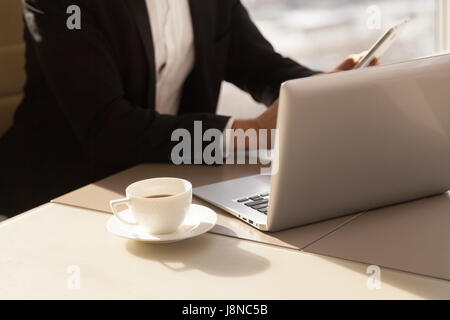 Businessman using mobile phone during coffee break Stock Photo
