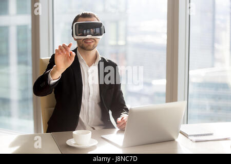 Man in VR headset touching virtual objects Stock Photo
