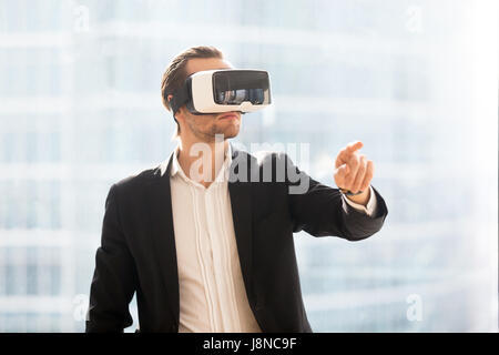 Man in VR headset using augmented reality in work Stock Photo