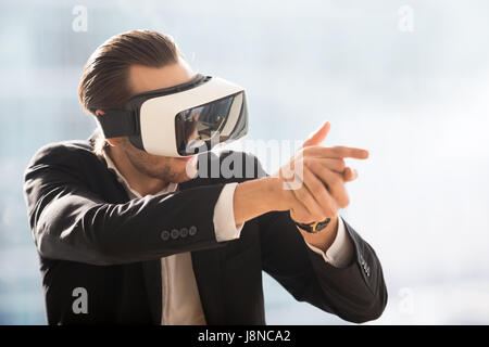 Man playing in shooter game with VR headset Stock Photo