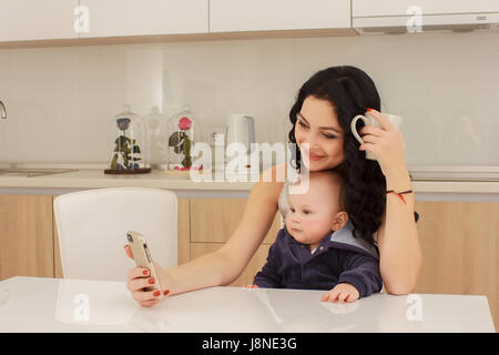 young mother and her son play and reading a book on sofa, lifestyle Stock Photo