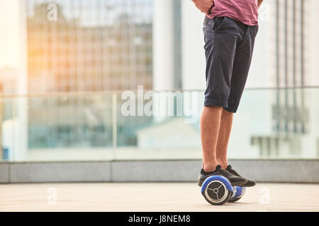 Legs of man on gyroscooter. Stock Photo