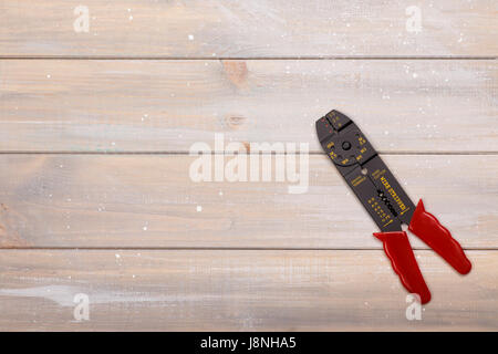 The electrician's tool for stripping and biting off the wires lies on a wooden background. There is room for text Stock Photo